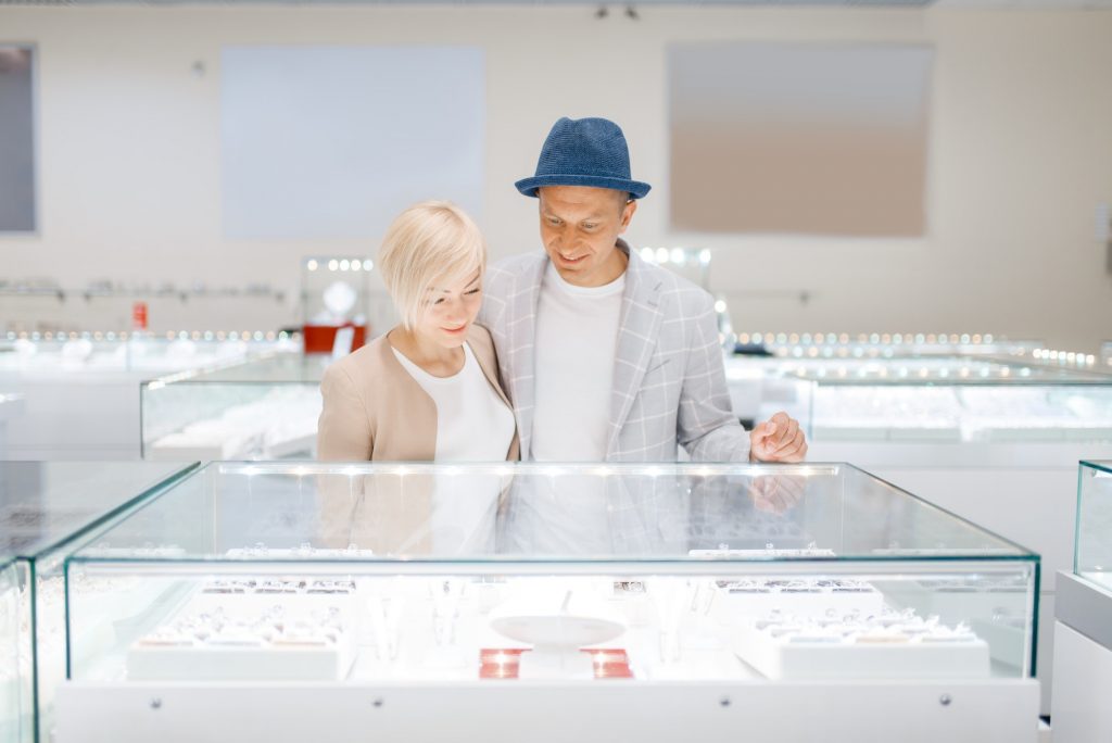 Love couple looking on jewels in jewelry store